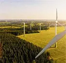 Image of wind turbine power generators in a field representing renewable energy and commodities market operations for risk analytics.