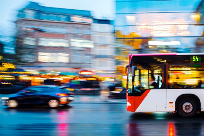 Stock image of cars and buses on driving at night, symbolic of Lacima's work in natural gas solutions for transportation, storage, and swing portfolios